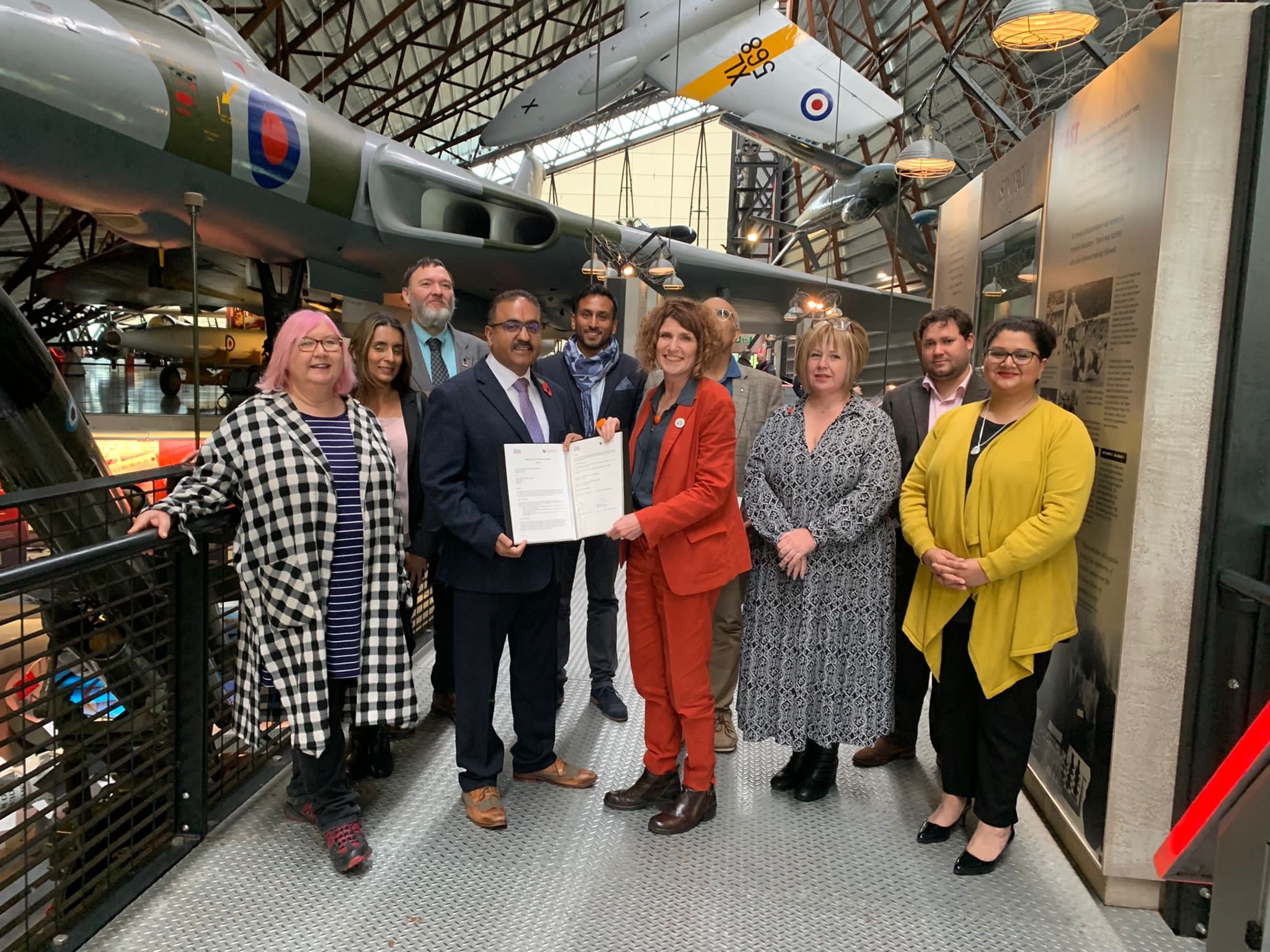 Representatives of Telford & Wrekin Interfaith Council and the RAF Museum Midlands gathered beneath an aircraft after signing their memorandum of understanding