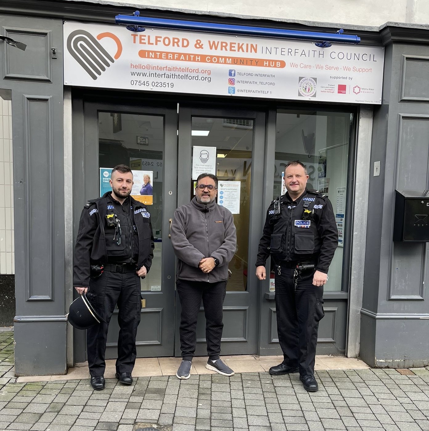 Police officers standing with a volunteer outside the Telford & Wrekin Interfaith Community Hub on New Street